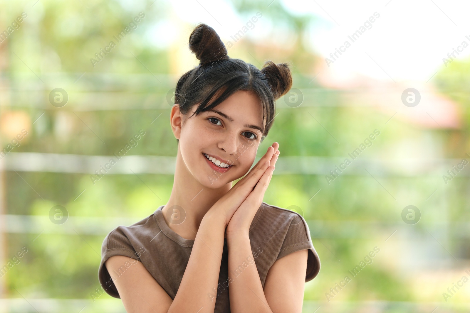 Photo of Portrait of smiling teenage girl on blurred background