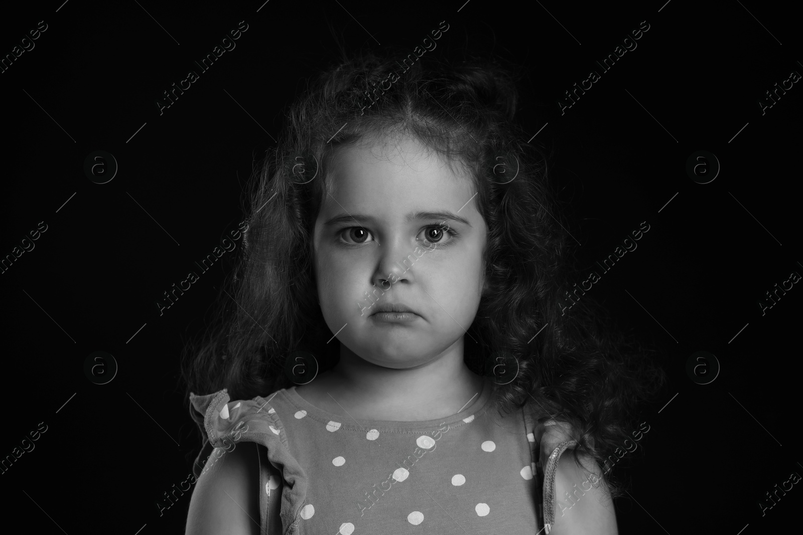 Photo of Portrait of sad girl on dark background. Black and white effect