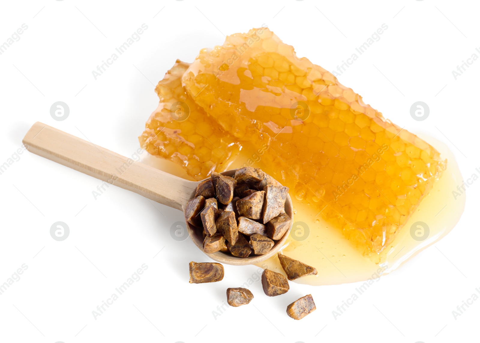 Photo of Sweet honeycombs and spoon with propolis granules isolated on white