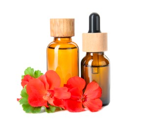 Photo of Bottles of geranium essential oil and beautiful flowers isolated on white