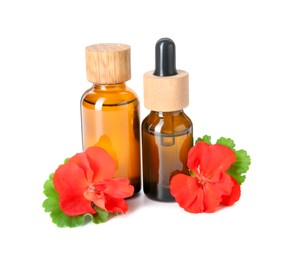 Photo of Bottles of geranium essential oil and beautiful flowers isolated on white