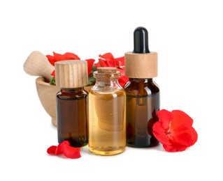 Bottles of geranium essential oil, mortar and pestle with beautiful flowers isolated on white