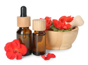 Bottles of geranium essential oil, mortar and pestle with beautiful flowers isolated on white