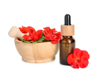 Photo of Bottle of geranium essential oil, mortar and pestle with beautiful flowers isolated on white