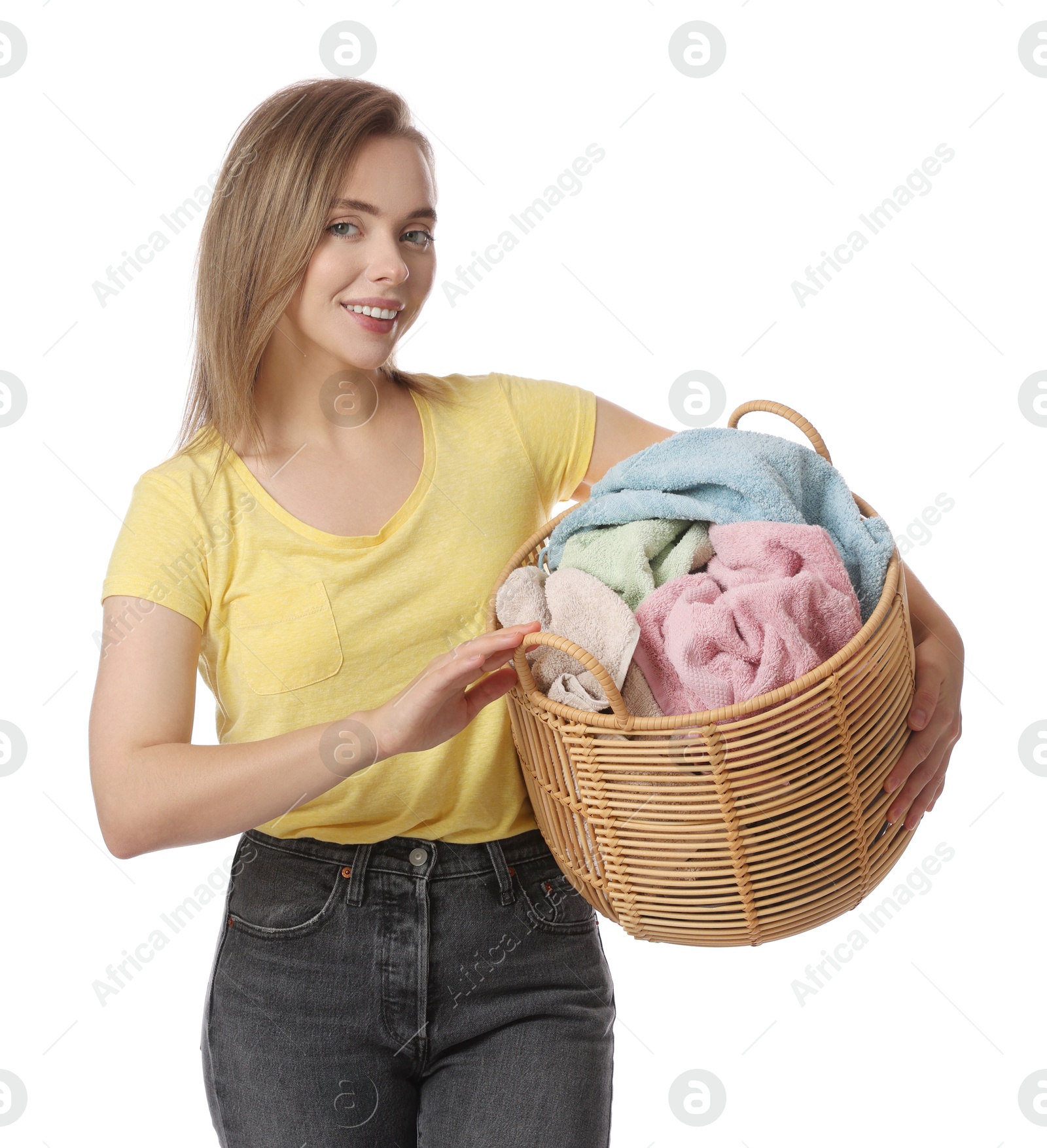 Photo of Happy young housewife with basket full of laundry on white background