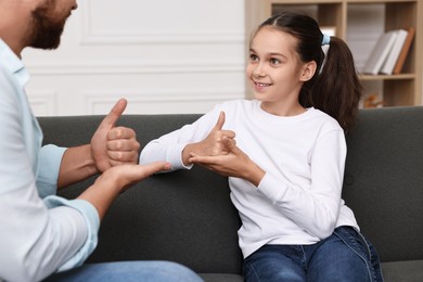 Man and his daughter using sign language for communication at home