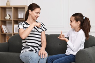 Woman and her daughter using sign language for communication at home