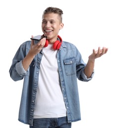 Young man recording voice message via smartphone on white background