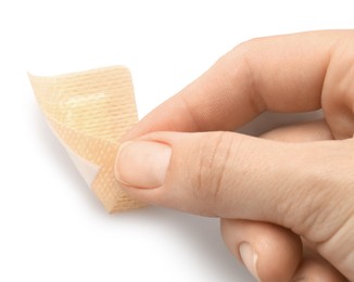 Photo of Woman putting medical adhesive bandage on white background, closeup