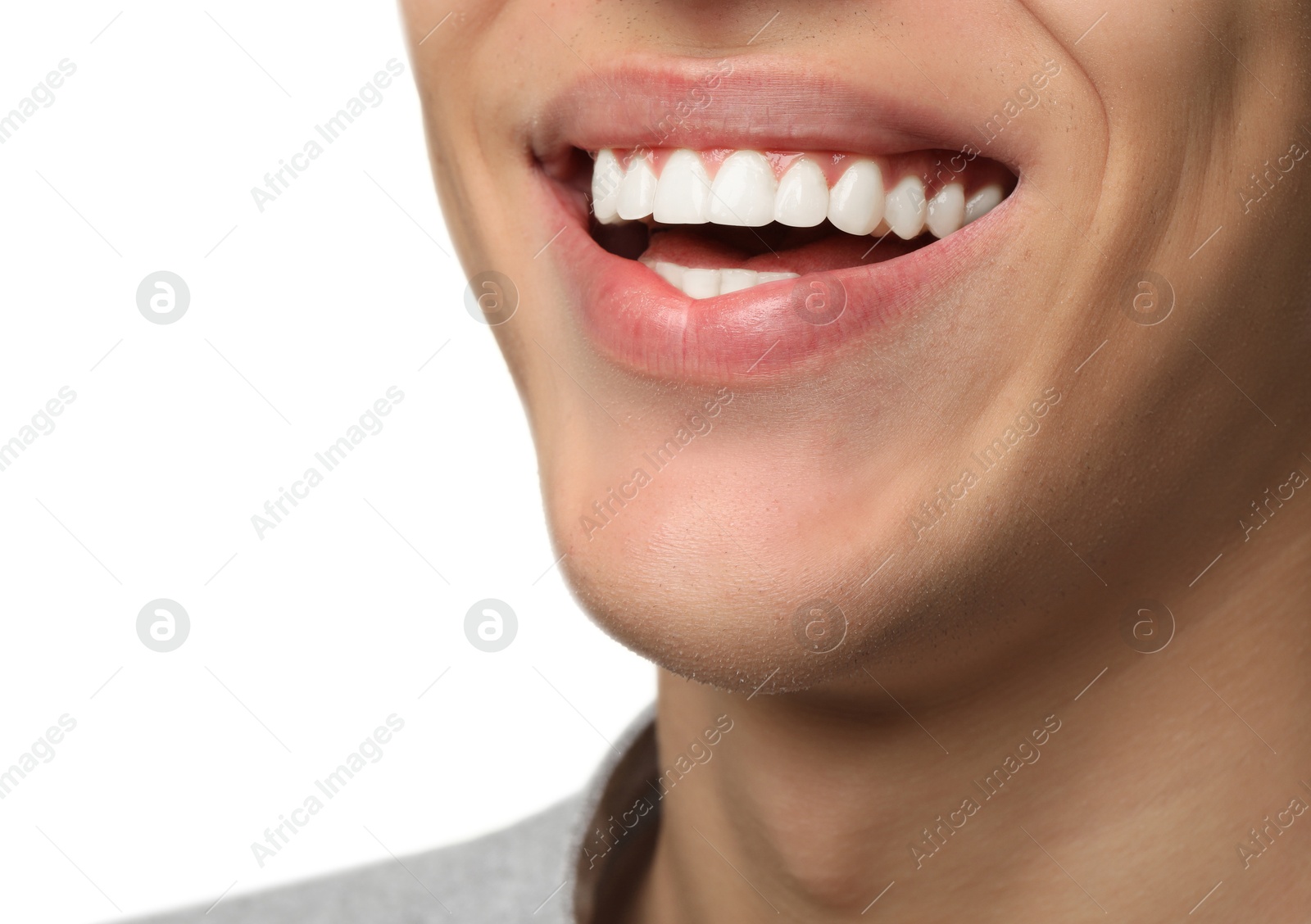 Photo of Happy young man on white background, closeup. Dental veneers