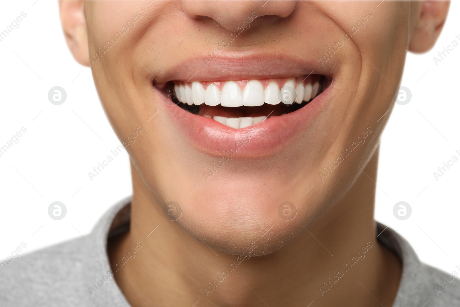 Photo of Happy young man on white background, closeup. Dental veneers