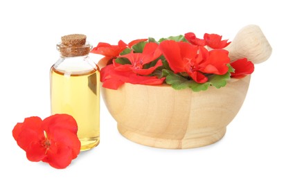 Photo of Bottle of geranium essential oil, mortar and pestle with beautiful flowers isolated on white