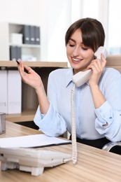 Professional receptionist talking on phone in office