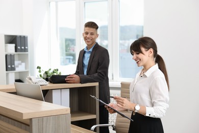 Professional receptionist working with client in office