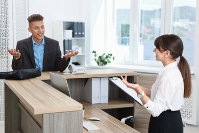 Photo of Professional receptionist working with client in office