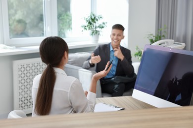 Photo of Professional receptionist working with client in office