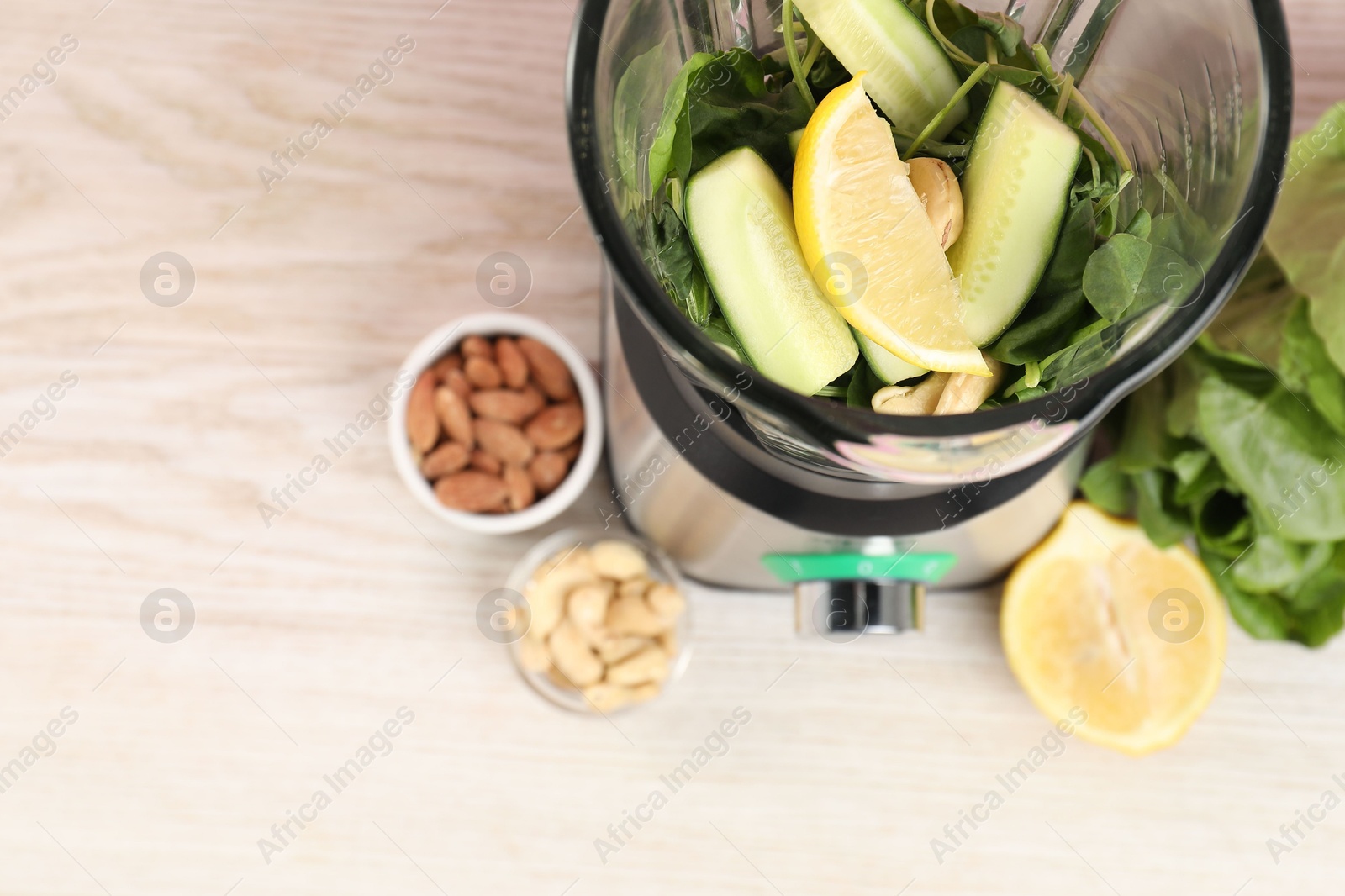 Photo of Modern blender with ingredients for smoothie on wooden table, top view. Space for text