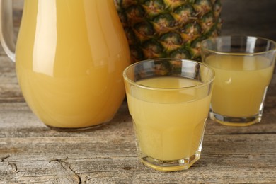 Photo of Tasty pineapple juice and fresh fruit on wooden table, closeup