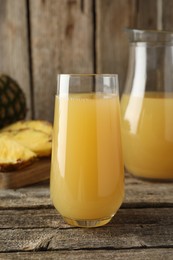 Photo of Tasty pineapple juice and fresh fruit on wooden table, closeup