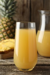 Photo of Tasty pineapple juice and fresh fruit on wooden table, closeup