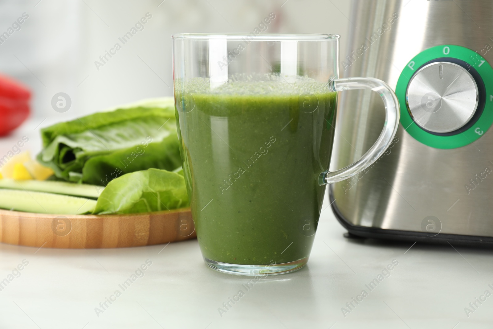 Photo of Delicious smoothie, modern blender and ingredients on white marble table