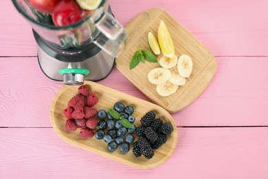 Blender and fresh ingredients on pink wooden table, top view