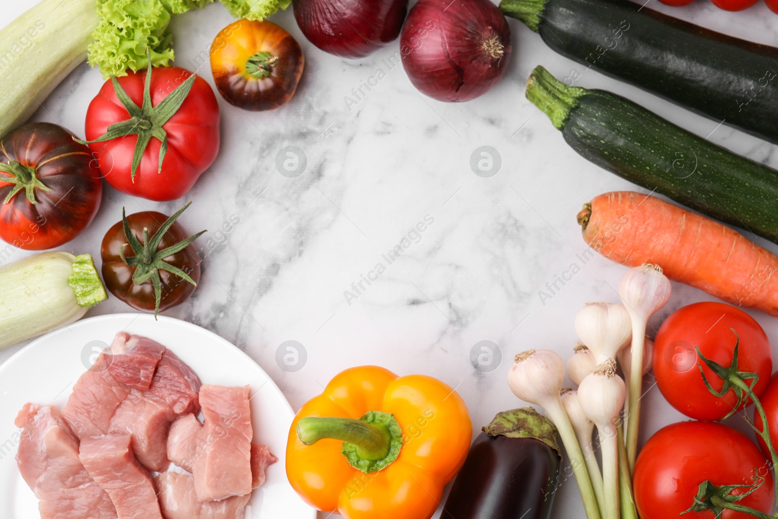 Photo of Different vegetables and raw meat for stew on white marble table, top view. Space for text