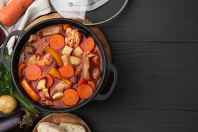 Photo of Tasty homemade stew with vegetables and bread on grey wooden table, flat lay. Space for text