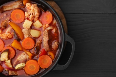 Tasty homemade stew with vegetables on grey wooden table, top view. Space for text