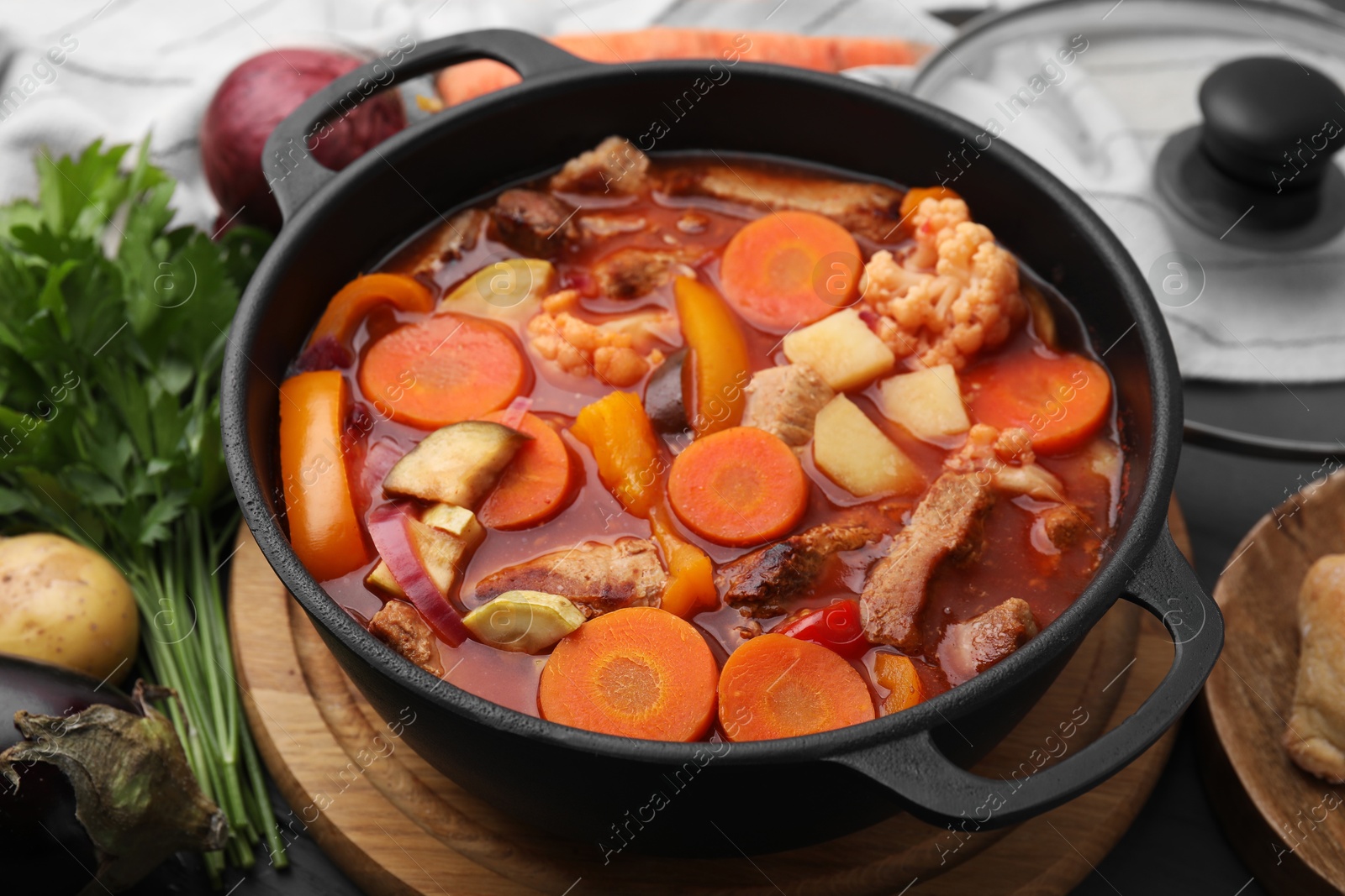 Photo of Tasty homemade stew with vegetables on grey wooden table, closeup