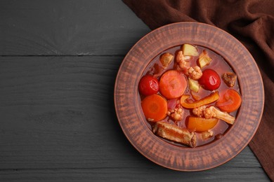 Tasty homemade stew with vegetables on grey wooden table, top view. Space for text