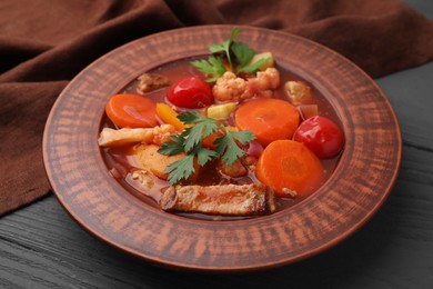 Tasty homemade stew with vegetables on grey wooden table, closeup