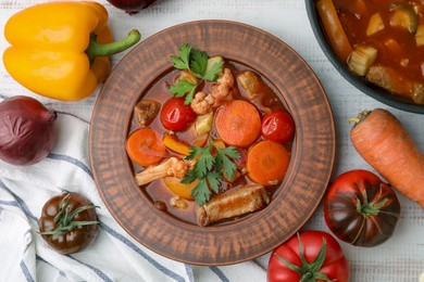 Photo of Tasty homemade stew with vegetables on white wooden table, flat lay