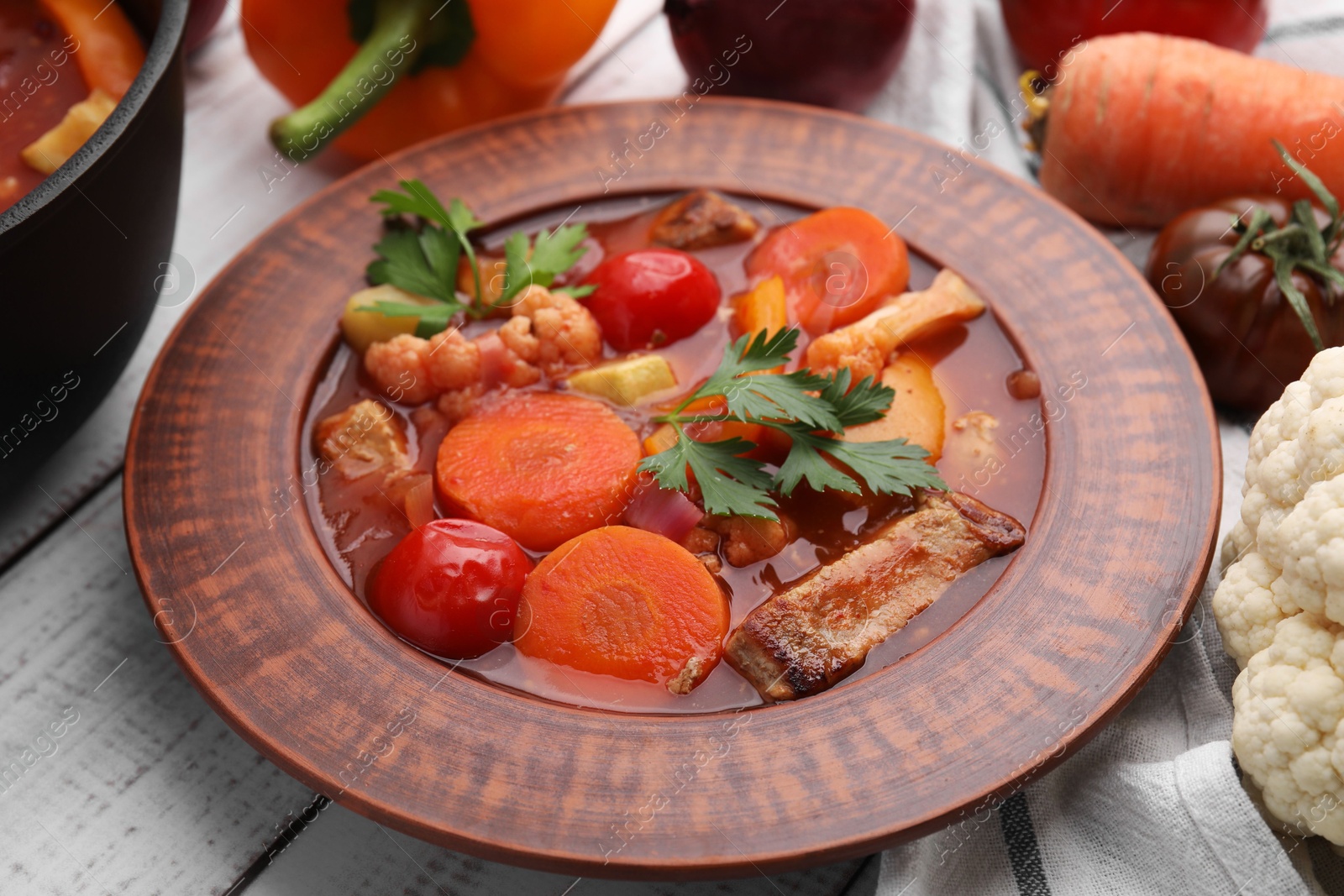 Photo of Tasty homemade stew with vegetables on white wooden table, closeup