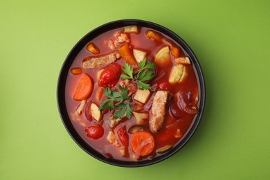 Photo of Tasty homemade stew with vegetables on light green table, top view