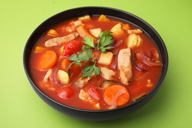 Tasty homemade stew with vegetables on light green table, closeup