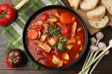 Photo of Tasty homemade stew with vegetables on wooden table, flat lay