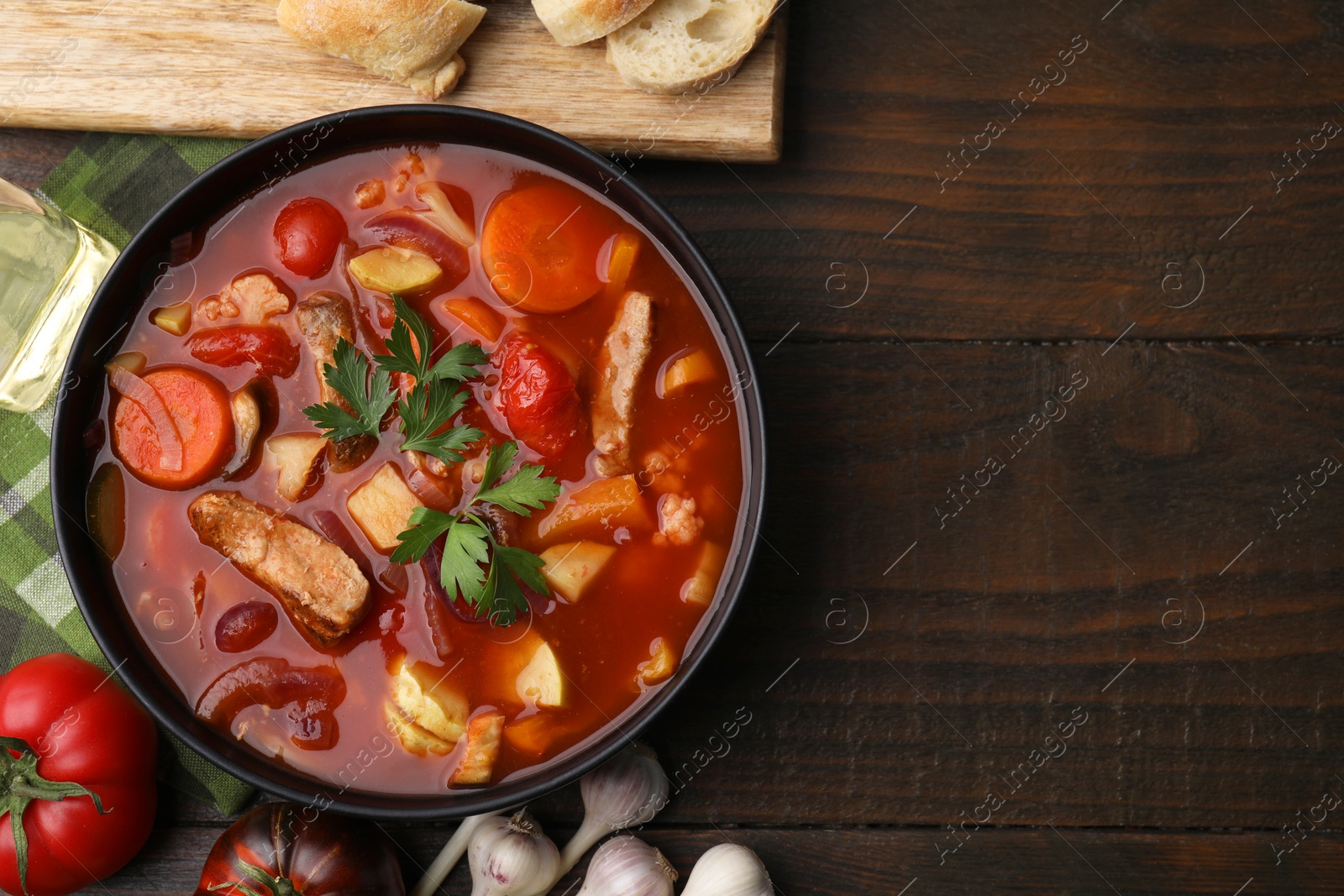 Photo of Tasty homemade stew with vegetables on wooden table, flat lay. Space for text