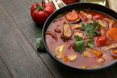 Photo of Tasty homemade stew with vegetables on wooden table, closeup. Space for text