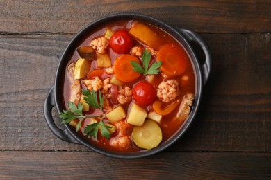 Tasty homemade stew with vegetables on wooden table, top view