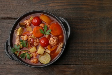 Tasty homemade stew with vegetables on wooden table, top view. Space for text