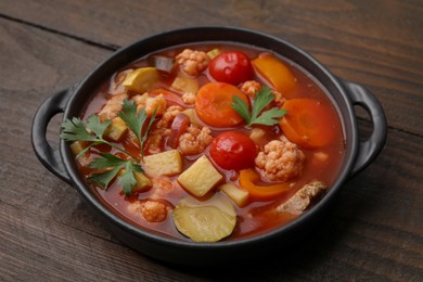 Photo of Tasty homemade stew with vegetables on wooden table, closeup