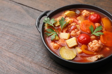 Photo of Tasty homemade stew with vegetables on wooden table, closeup. Space for text