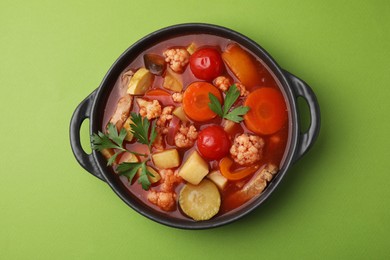 Photo of Tasty homemade stew with vegetables on light green table, top view