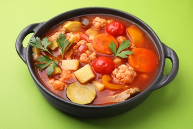 Tasty homemade stew with vegetables on light green table, closeup