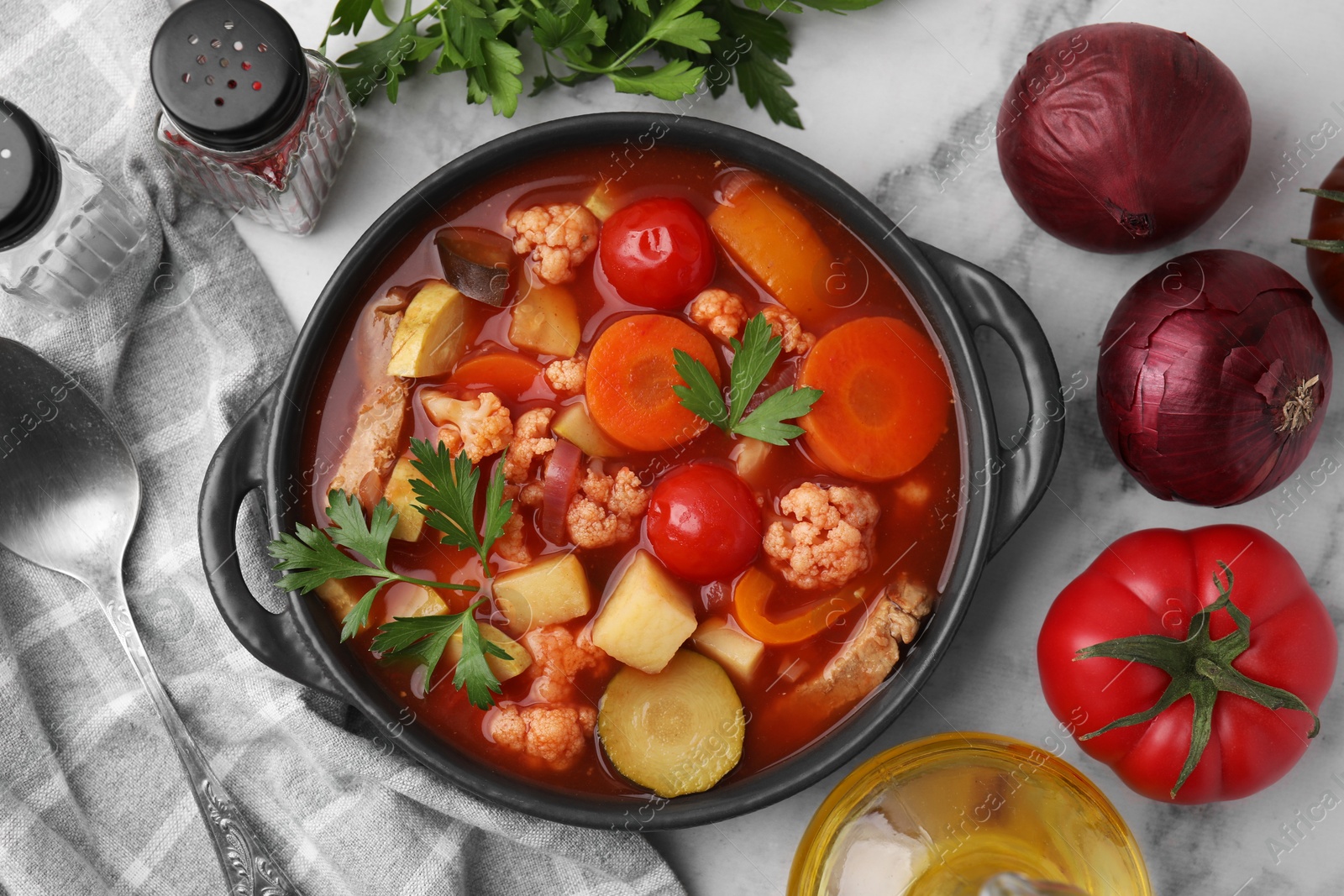 Photo of Tasty homemade stew with vegetables on white marble table, flat lay