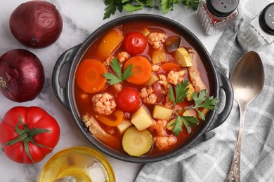 Photo of Tasty homemade stew with vegetables on white marble table, flat lay