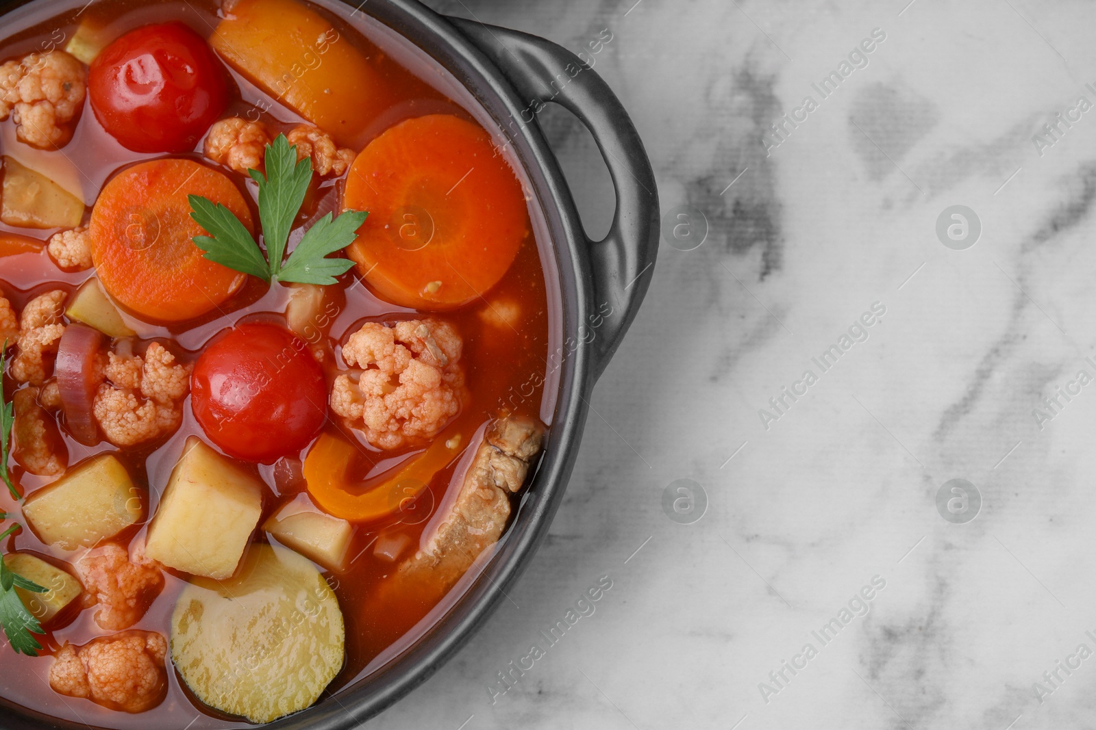 Photo of Tasty homemade stew with vegetables on white marble table, top view. Space for text