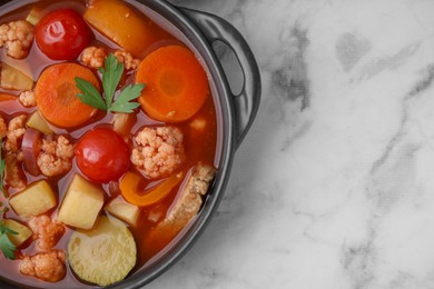 Tasty homemade stew with vegetables on white marble table, top view. Space for text