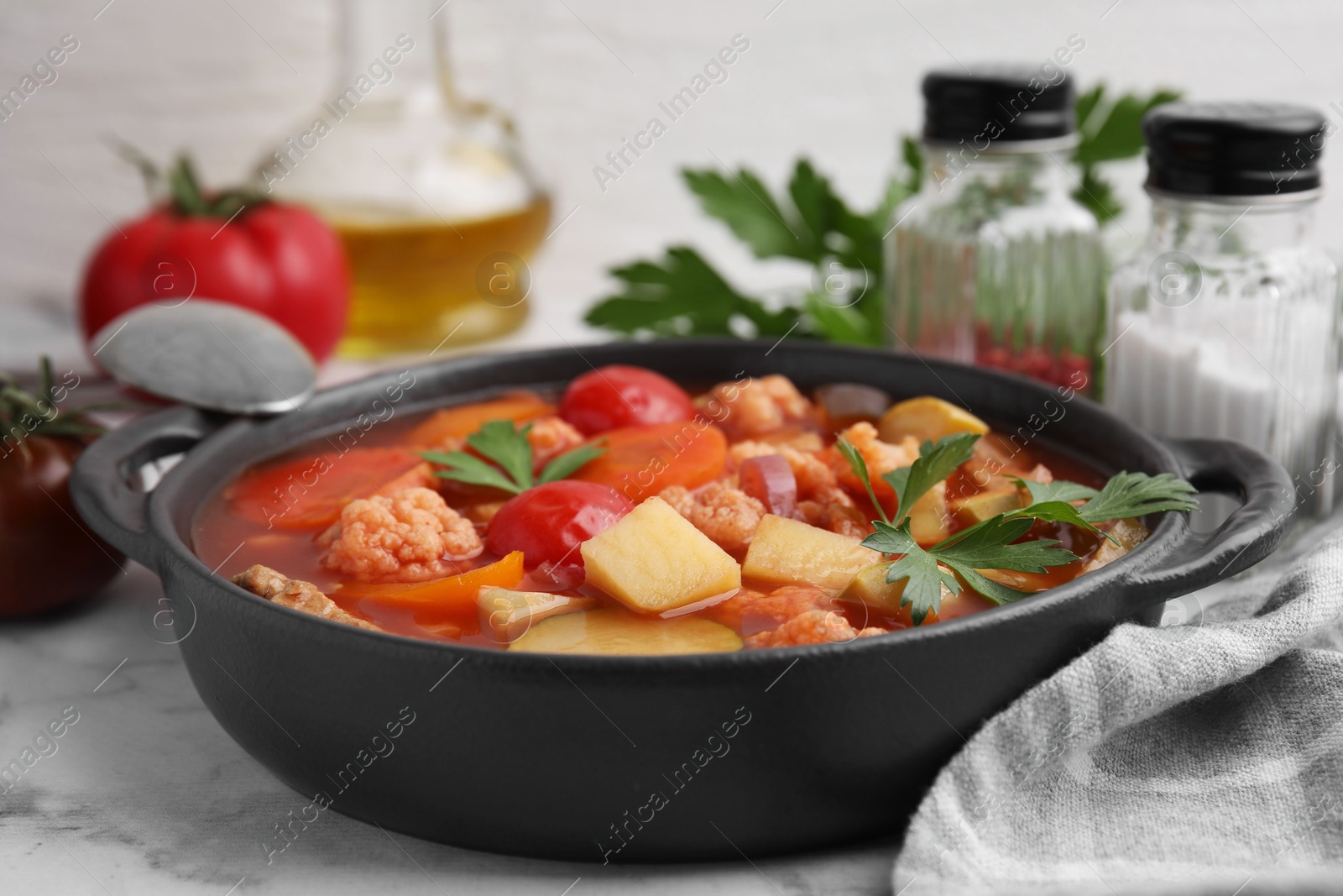 Photo of Tasty homemade stew with vegetables on white marble table, closeup